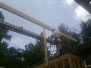 Carpenter setting a ridge beam over a new addition frame — Ice Dam Removal by Roofing Brothers in White Oak