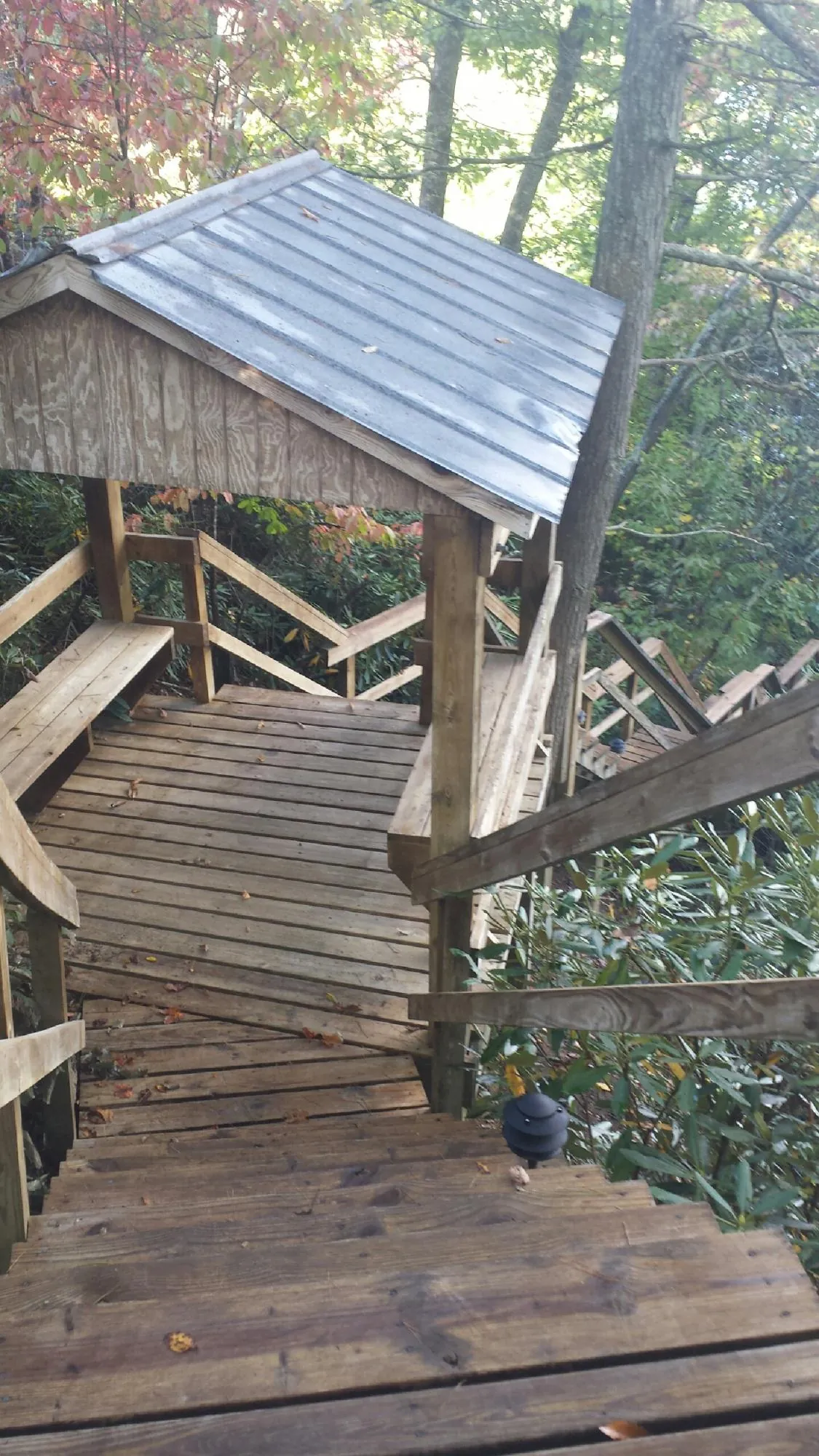 Metal roofed shelter over wooden steps on a wooded walkway — Skylight Repair & Installation work by our crew in White Oak