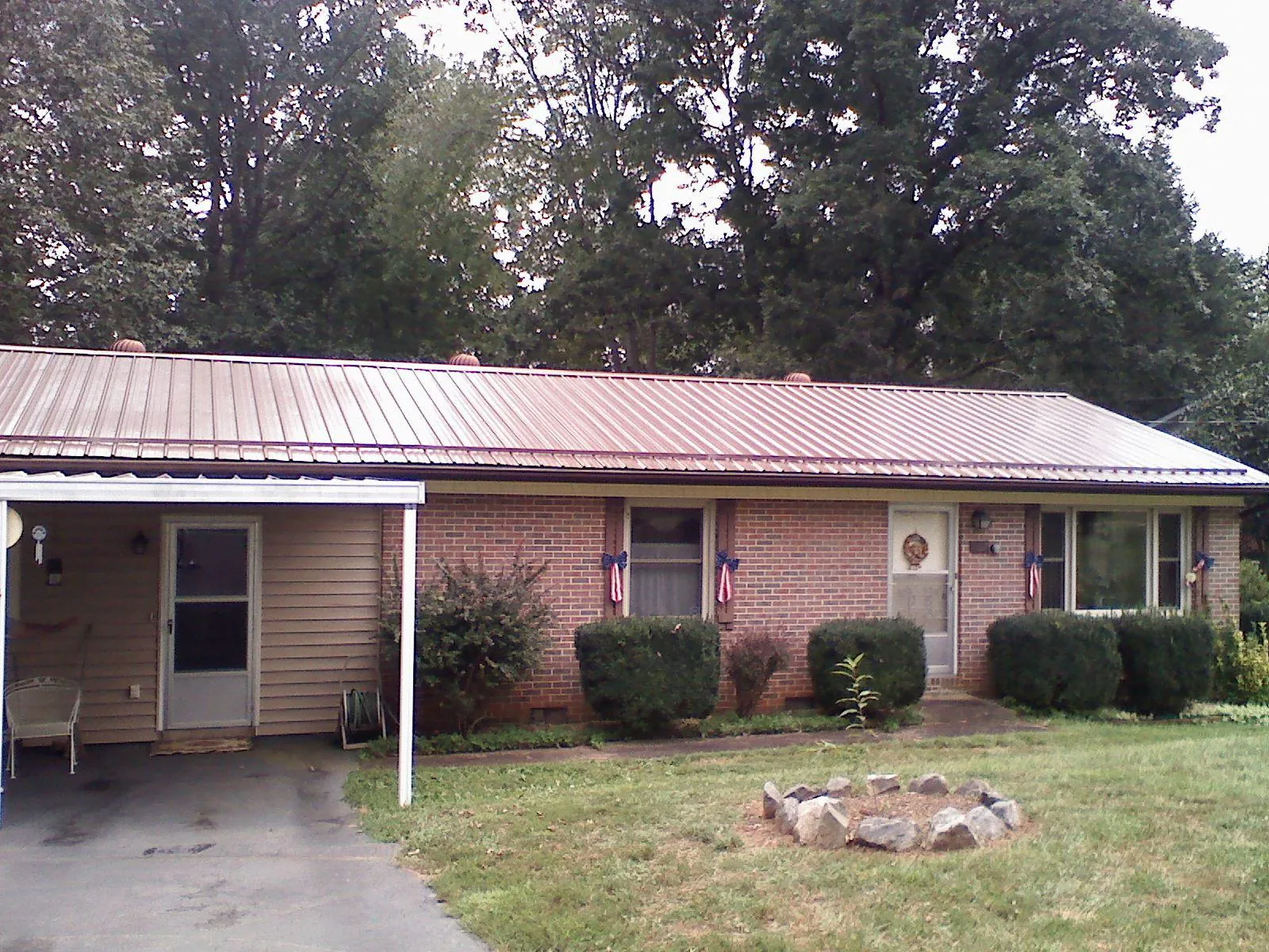 Bronze metal roof and carport on a brick ranch home — Roof Repair work by our crew in White Oak
